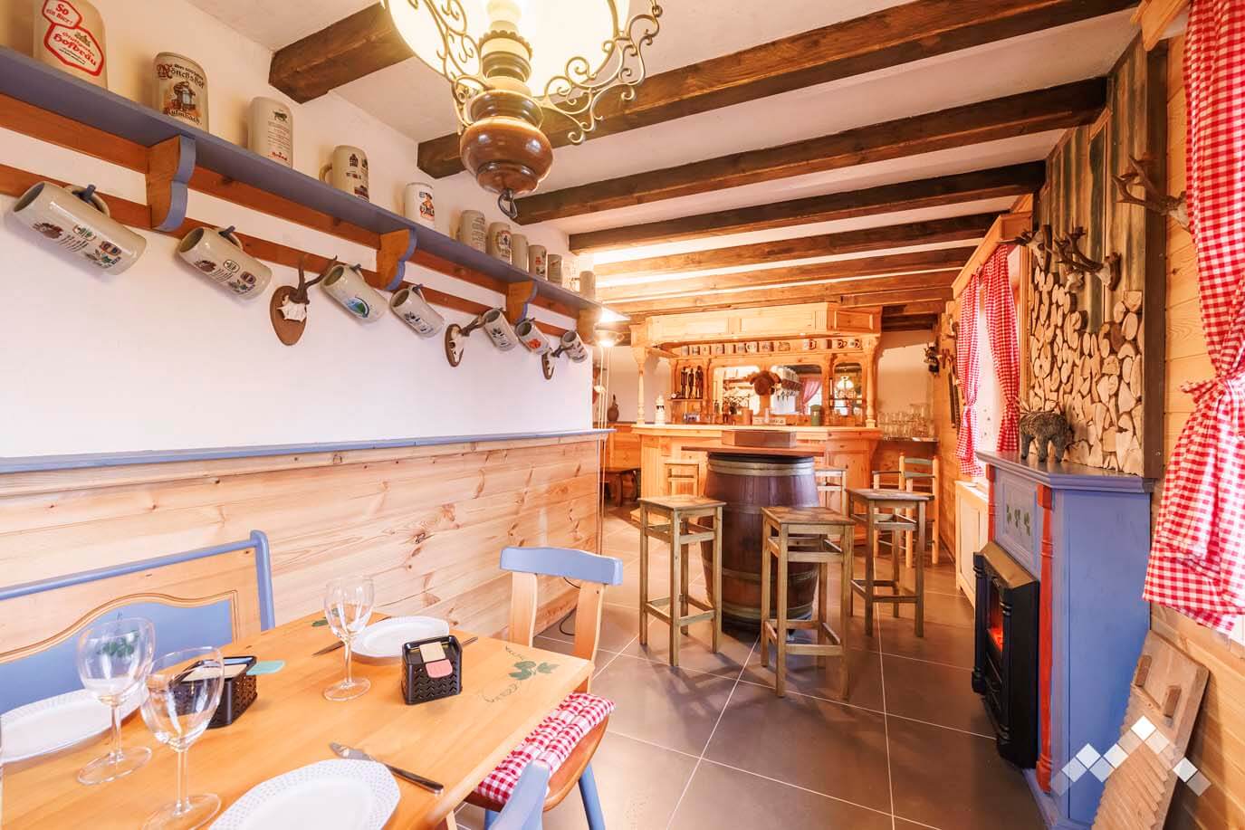 Coin bar et espace détente rustique au rez-de-chaussée du chalet La Parenthèse pour des soirées conviviales.